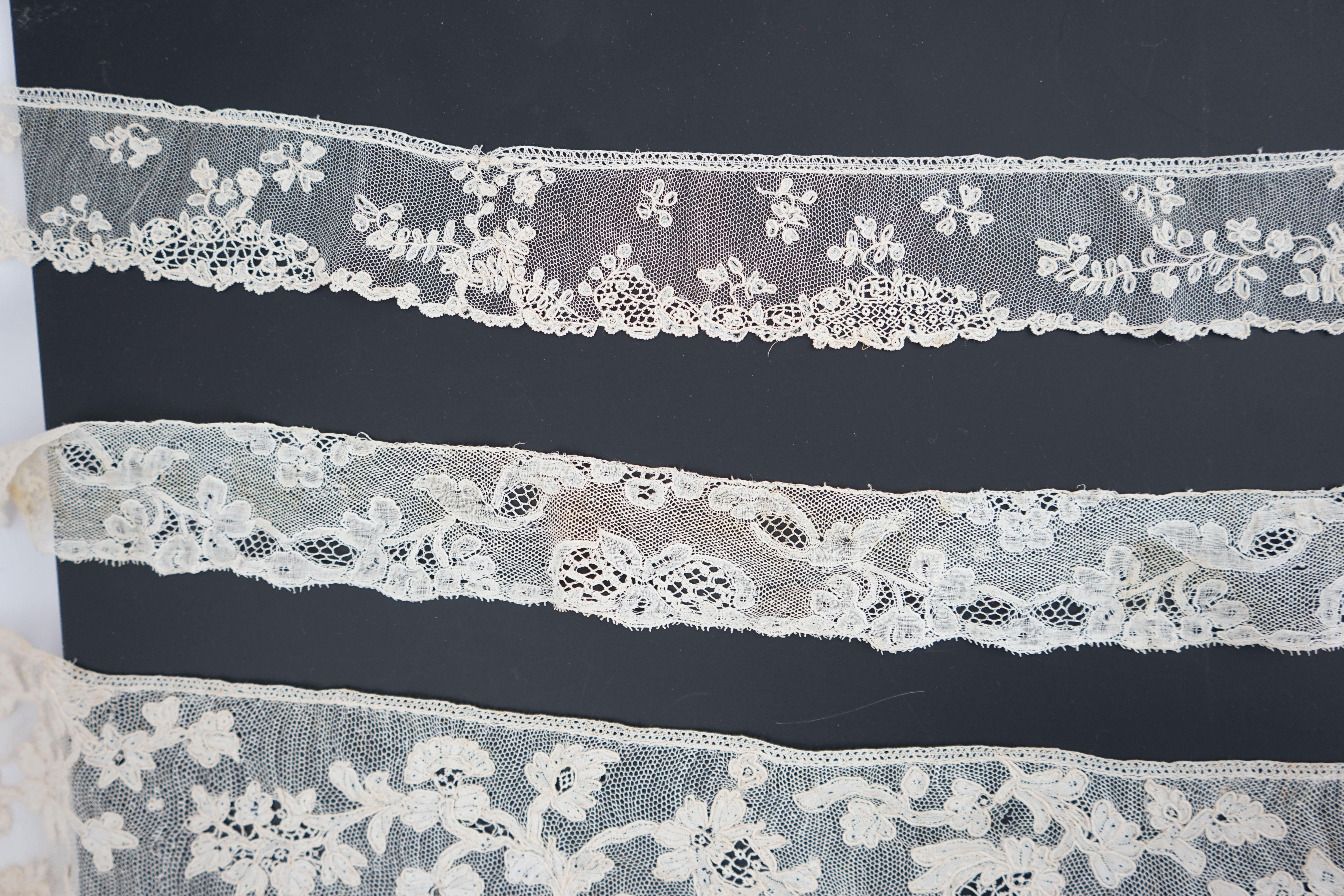 A large section of an ornate 19th century Brussels bobbin lace wedding veil, with two finished edges and one cut edge together with 18th century and later needle lace, an Argentan and an Alencon trimming, possibly an 18t